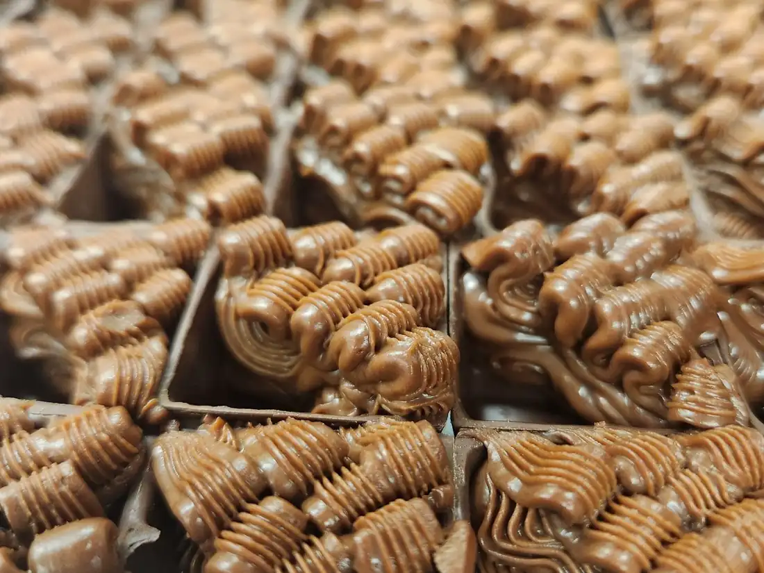 Ganache de chocolate pipada em cordões nas cascas de bombom