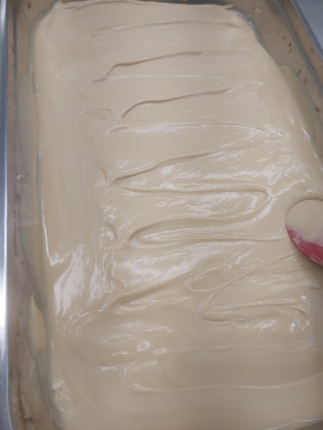 Buttercream já recuperada, espalhada lisa e brilhante, sem nenhum grumo visível