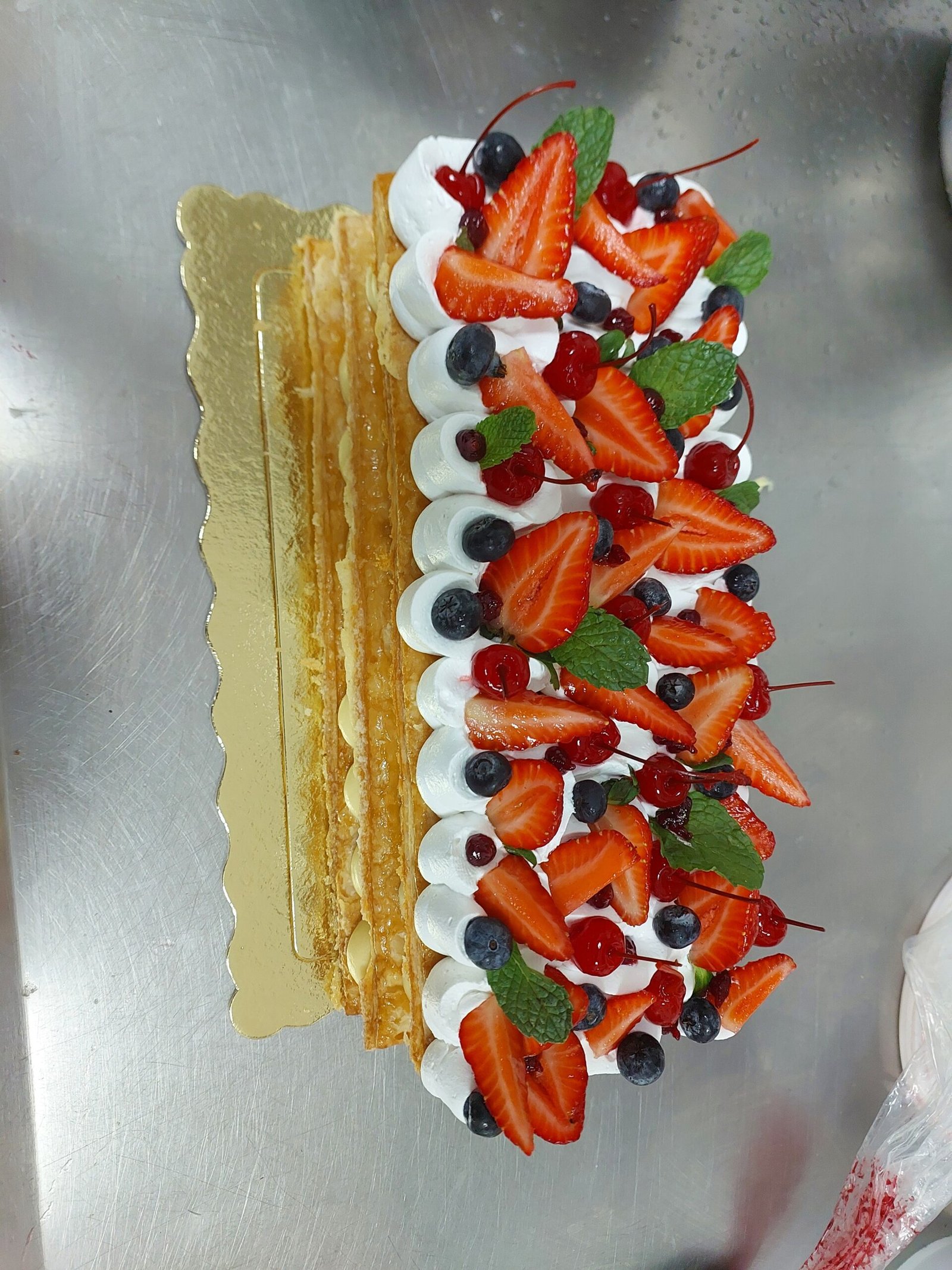 Mil-folhas com camadas de creme diplomata entre o folhado, coberto de frutas vermelhas frescas