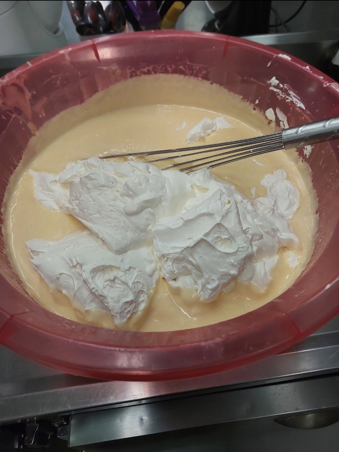 O momento exato da dobra: espuma de ar ainda intacta sendo incorporada ao chocolate, antes de homogeneizar