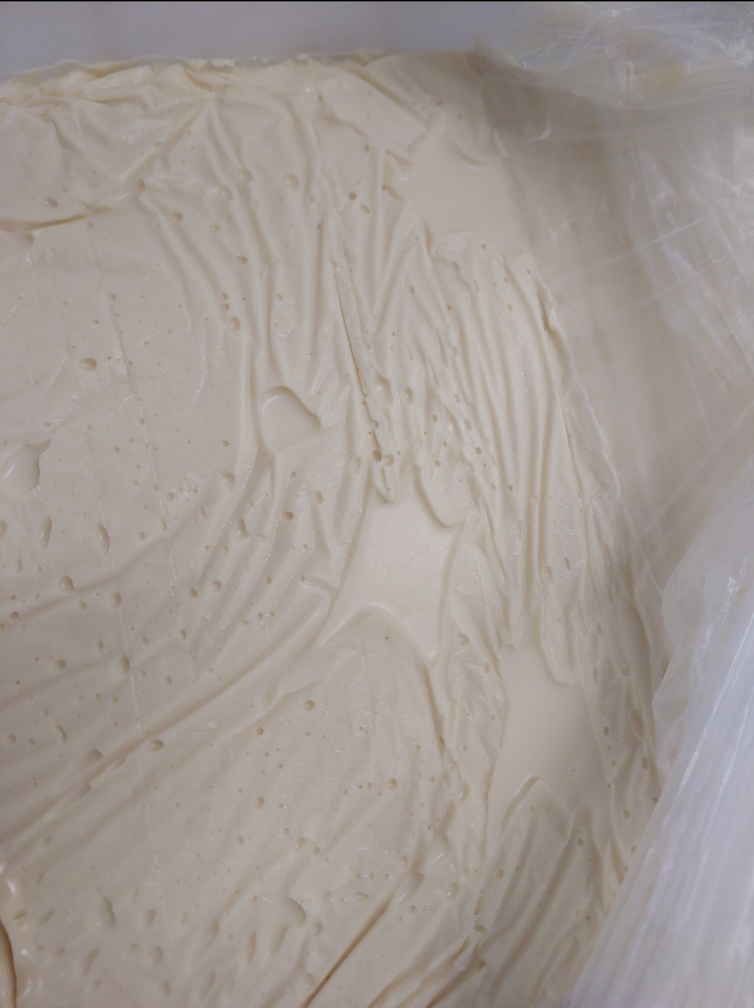 Uma camada de barreira de gordura firme e bem cristalizada é o que sela a umidade do bolo antes da pasta ser aplicada.