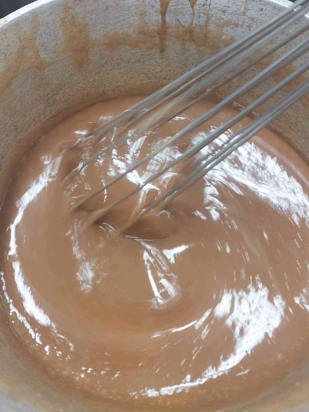 Caramelo sendo mexido na panela — a mesma agitação que, depois da fervura, pode soltar cristais grudados na parede e disparar a cristalização