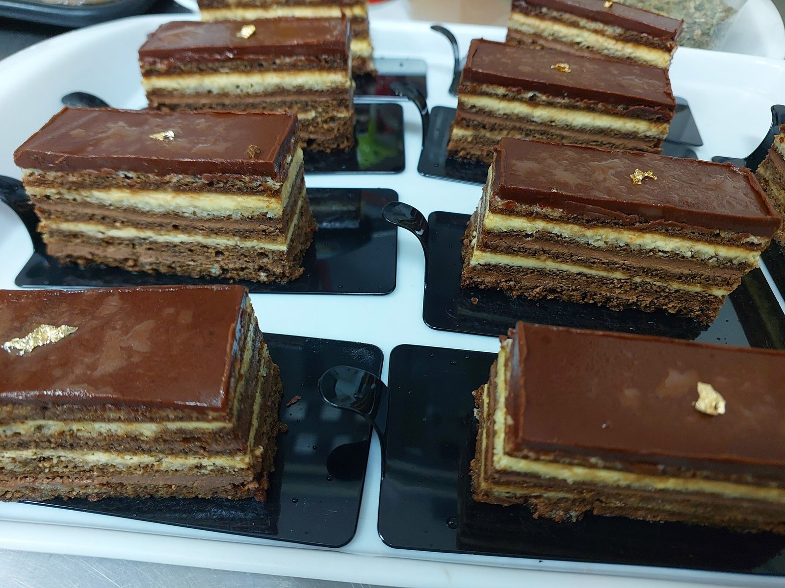 fatias de ópera mostrando as camadas finas (joconde, ganache, buttercream) descritas no texto