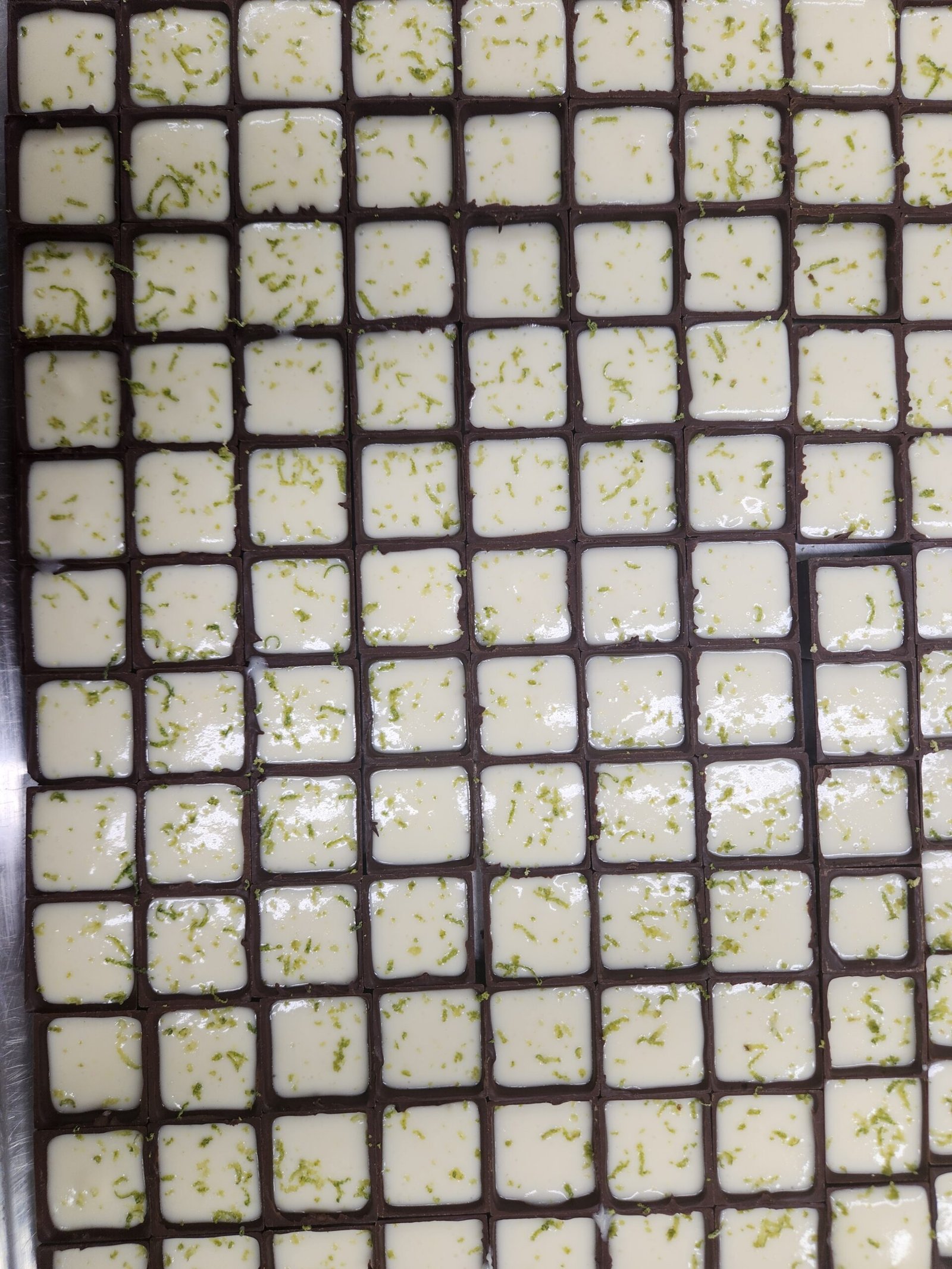 placa de bombons quadrados com cordões de chocolate ligando as bordas e contorno irregular de excesso endurecido