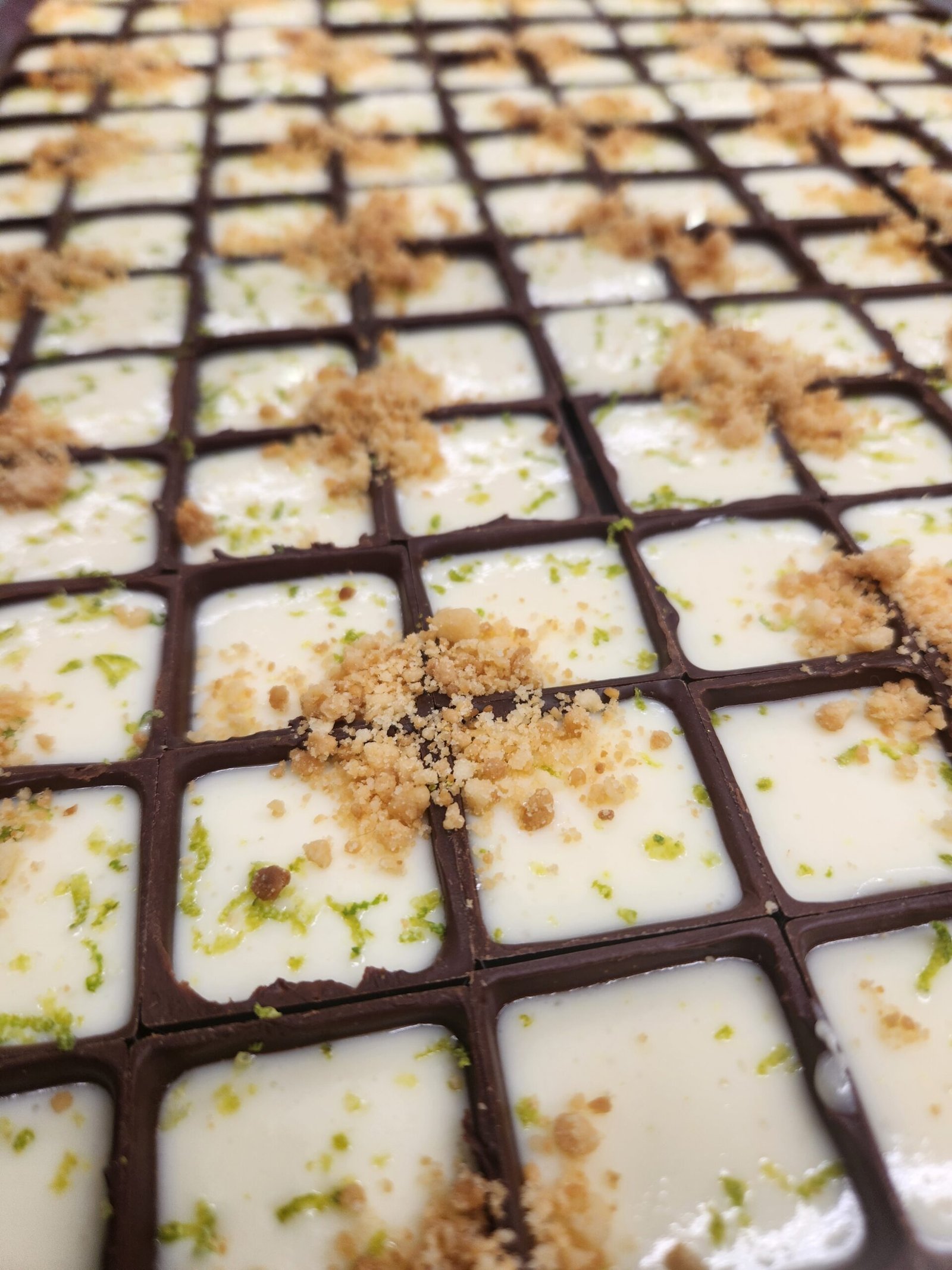 mesma bandeja em ângulo rasante, contraste de brilho entre as bordas de chocolate