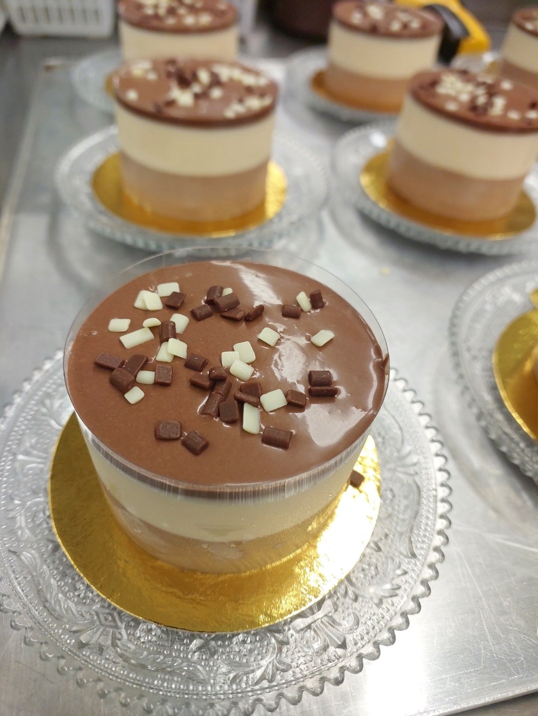peças frias individuais com camadas horizontais nítidas e limite reto entre elas (substituto aproximado: entremet de três chocolates, não cheesecake — mesma estrutura de peça fria maturada antes do desmolde)