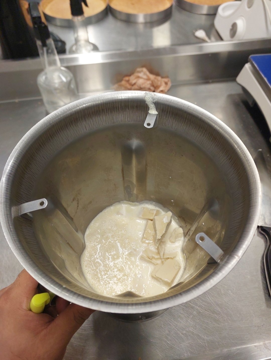 Creme quente vertido sobre o chocolate picado na cuba: o momento imediatamente anterior à emulsificação