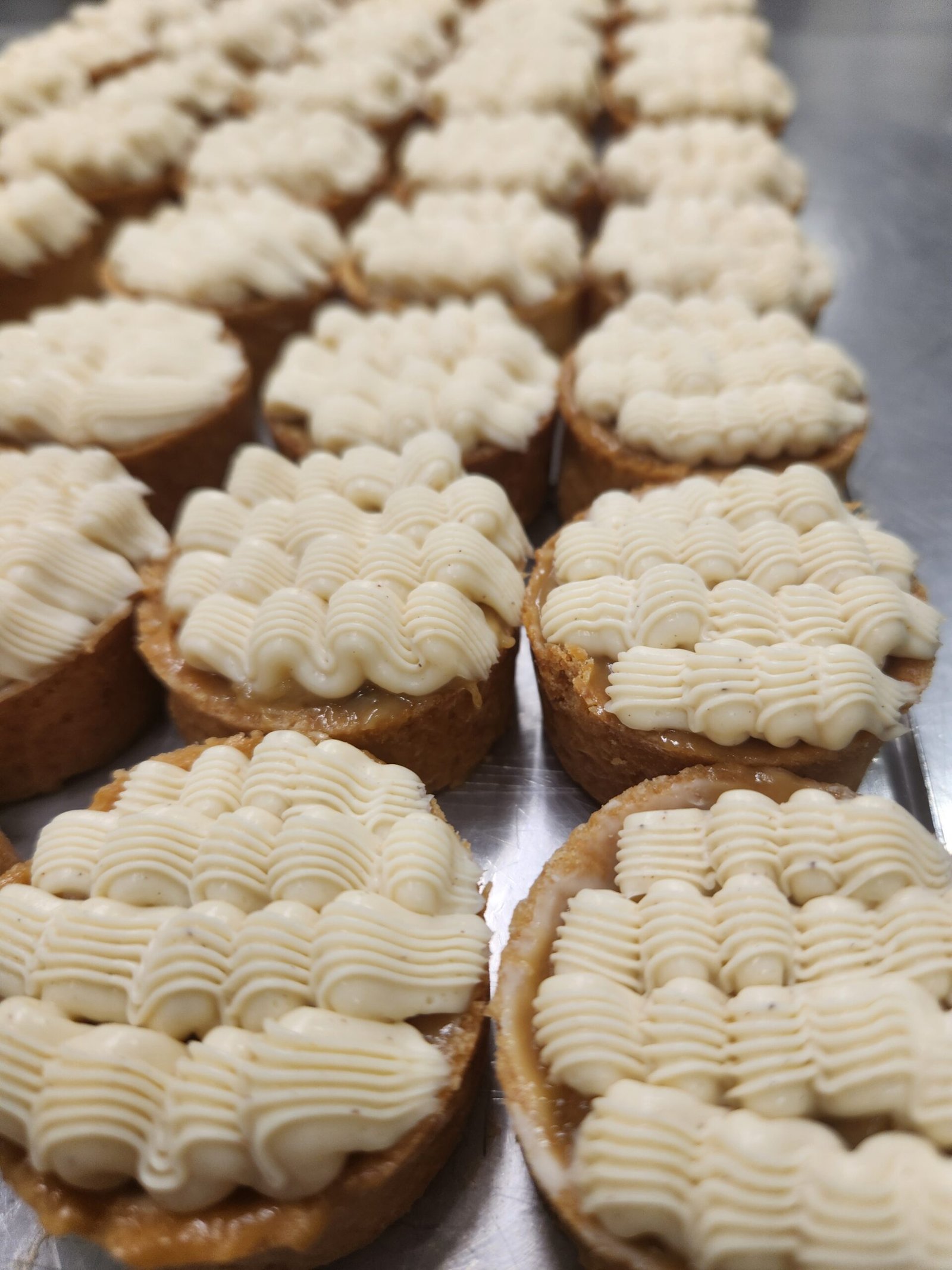 fileiras de tartelettes recheadas em sequência, com a borda assada aparecendo em volta de cada recheio