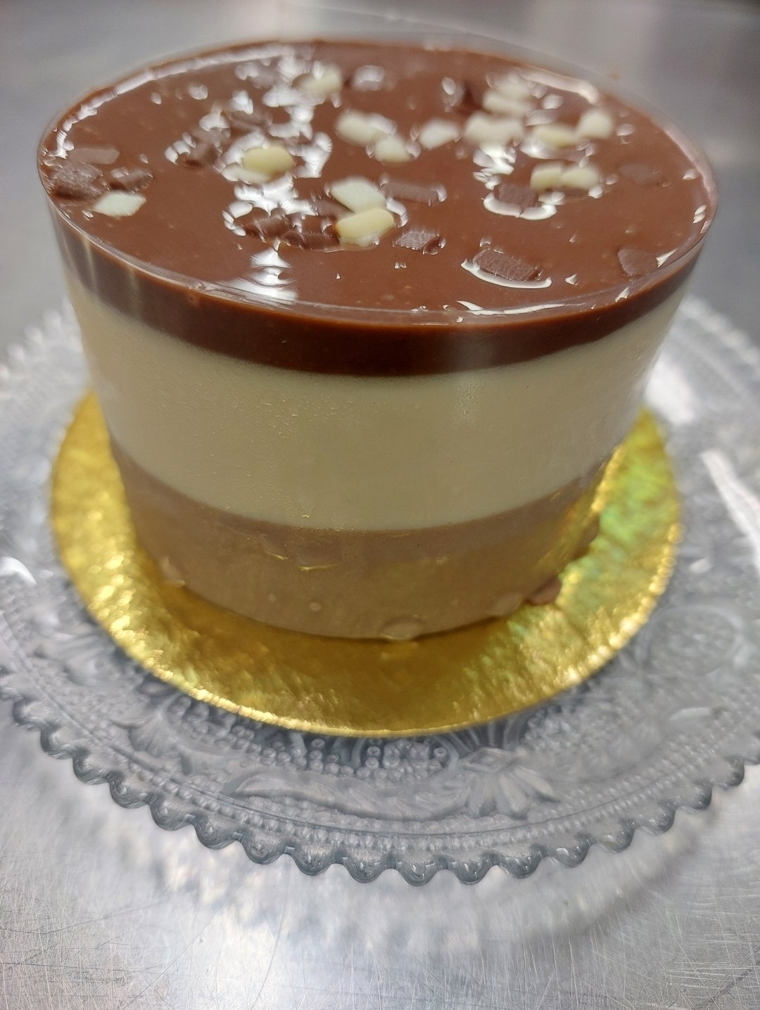 peça individual desenformada com três camadas de mousse nítidas e laterais retas (substituto aproximado: mousses de chocolate, não de cream cheese — mesma exigência estrutural de camada que desenforma)