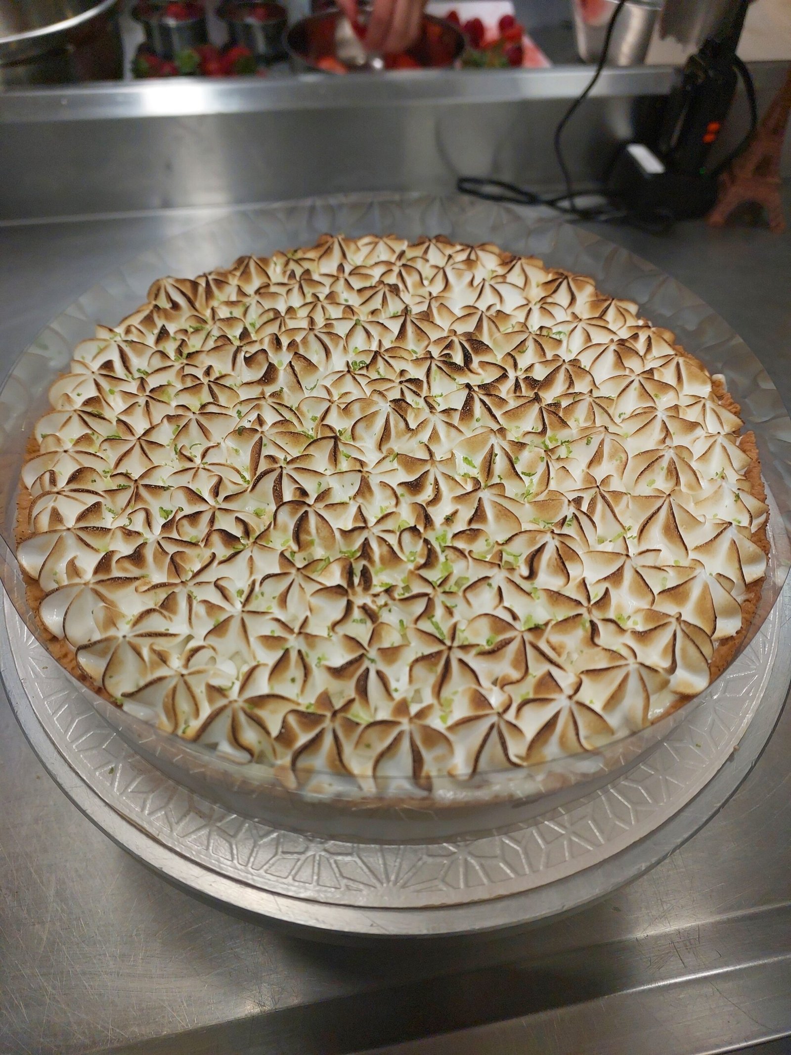tarte grande de merengue maçaricado com a faixa de massa contornando a peça em altura regular