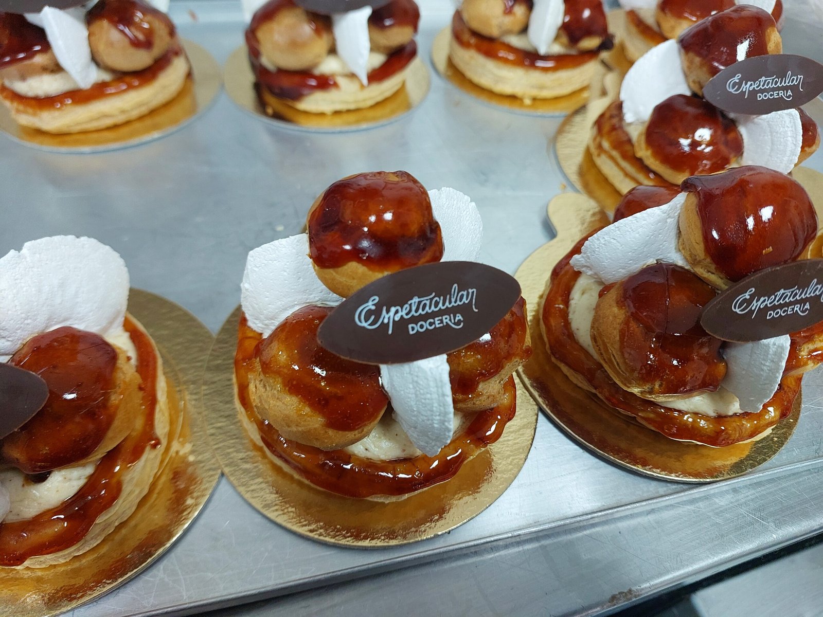 caramelo vitrificado brilhante cobrindo a superfície dos choux, camada fina e uniforme (substituto aproximado: caramelo de Saint-Honoré, não crosta de brûlée — mesma estrutura de açúcar cozido vitrificado)