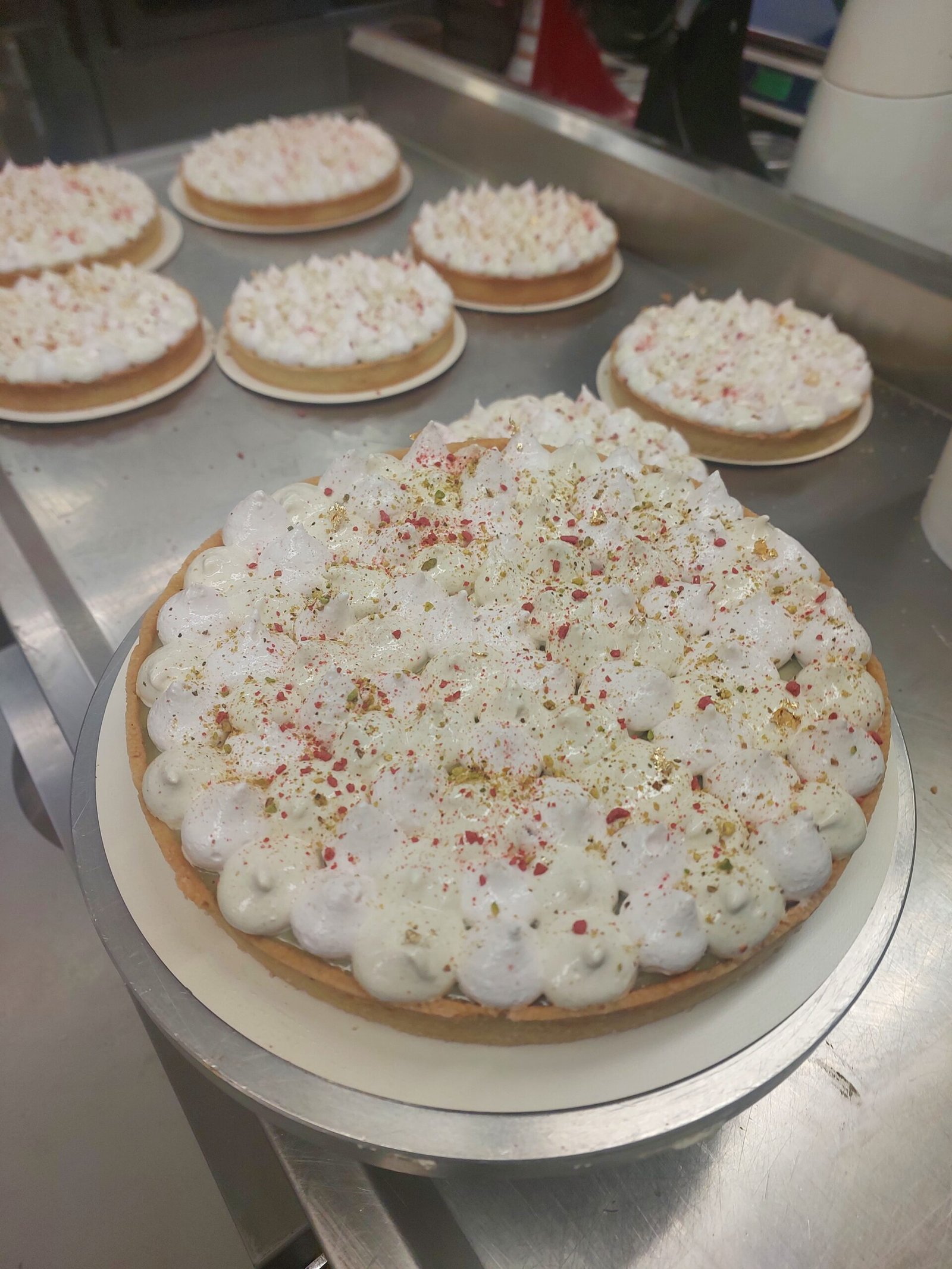 tarte grande coberta de quenelles de merengue branco, com a borda de massa visível ao redor de todo o perímetro