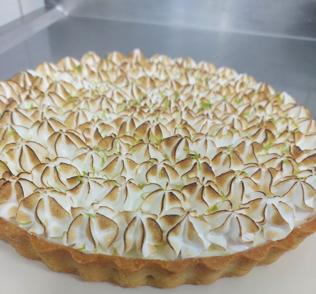 mesma torta em ângulo rasante, mostrando o contraste entre a ponta dourada e a base branca de cada pico