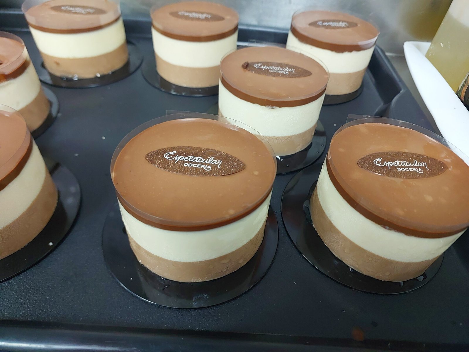 Disco fino de chocolate sobre camadas de mousse macia: placa rígida sobre base mole, o mesmo contraste da casca do panetone.