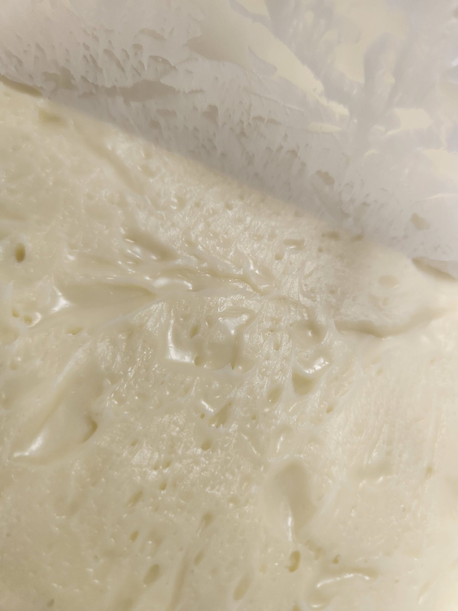 Ganache de chocolate branco cristalizada, firme e brilhante, com as marcas da espátula.