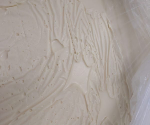 Uma camada de barreira de gordura firme e bem cristalizada é o que sela a umidade do bolo antes da pasta ser aplicada.